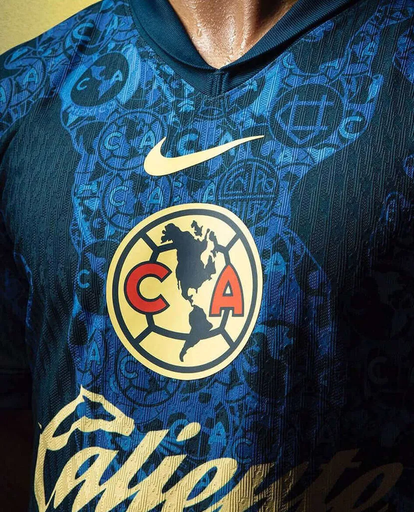Áo đấu sân khách Club America 2024/25 của Nike, với huy hiệu trung tâm lớn và họa tiết logo lặp lại.