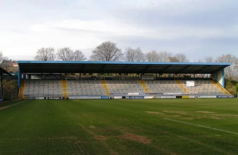Khán đài Bắc (North Stand) của sân The Shay, khu vực thường dành cho người hâm mộ đội khách, với thiết kế hiện đại được hoàn thành vào giữa thập niên 1990.
