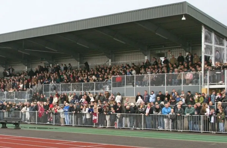 Khán giả cổ vũ trên khán đài chính của sân vận động Melbourne Community trong một trận đấu của Chelmsford City FC