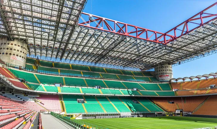 Không gian bên trong sân vận động San Siro với khán đài và sân cỏ xanh mướt trước trận đấu
