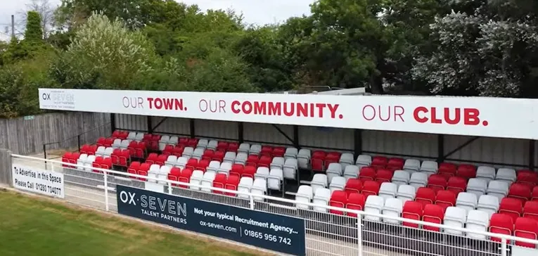 Khu vực khán đài có mái che tại St. James Park Brackley, nơi người hâm mộ có thể tránh mưa và nắng, tạo nên không khí cổ vũ cuồng nhiệt cho Brackley Town.