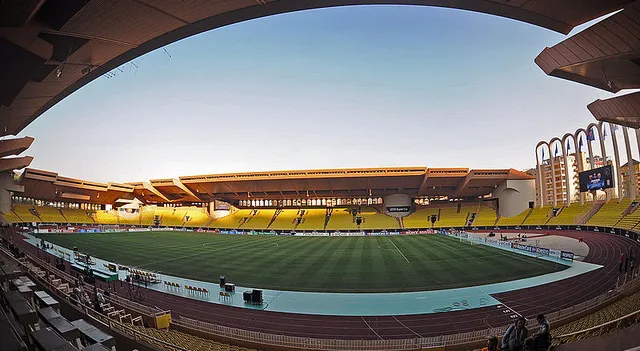 Sân vận động Stade Louis II nhìn từ xa với các khán đài và đường chạy điền kinh, thể hiện kiến trúc độc đáo