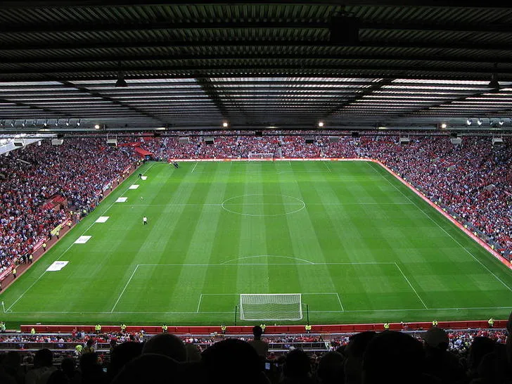 Toàn cảnh sân cỏ xanh mướt và khán đài của Old Trafford, sẵn sàng cho trận đấu.